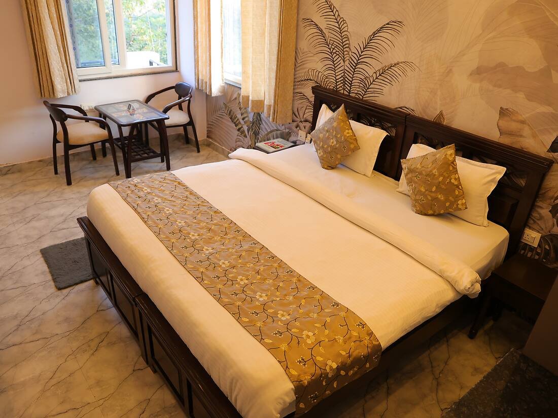 Deluxe room with king-size bed at Haritha Yogshala